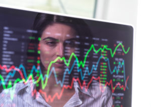 Female analyst viewing financial market data on a screen. Female analyst viewing financial market data on a screen.